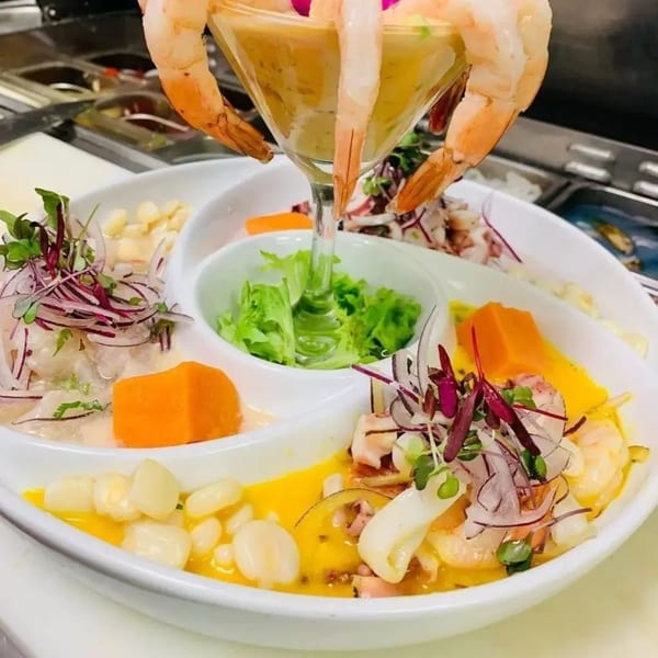 Peruvian ceviche platter with shrimp, octopus, fish, corn, sweet potato, and red onion.